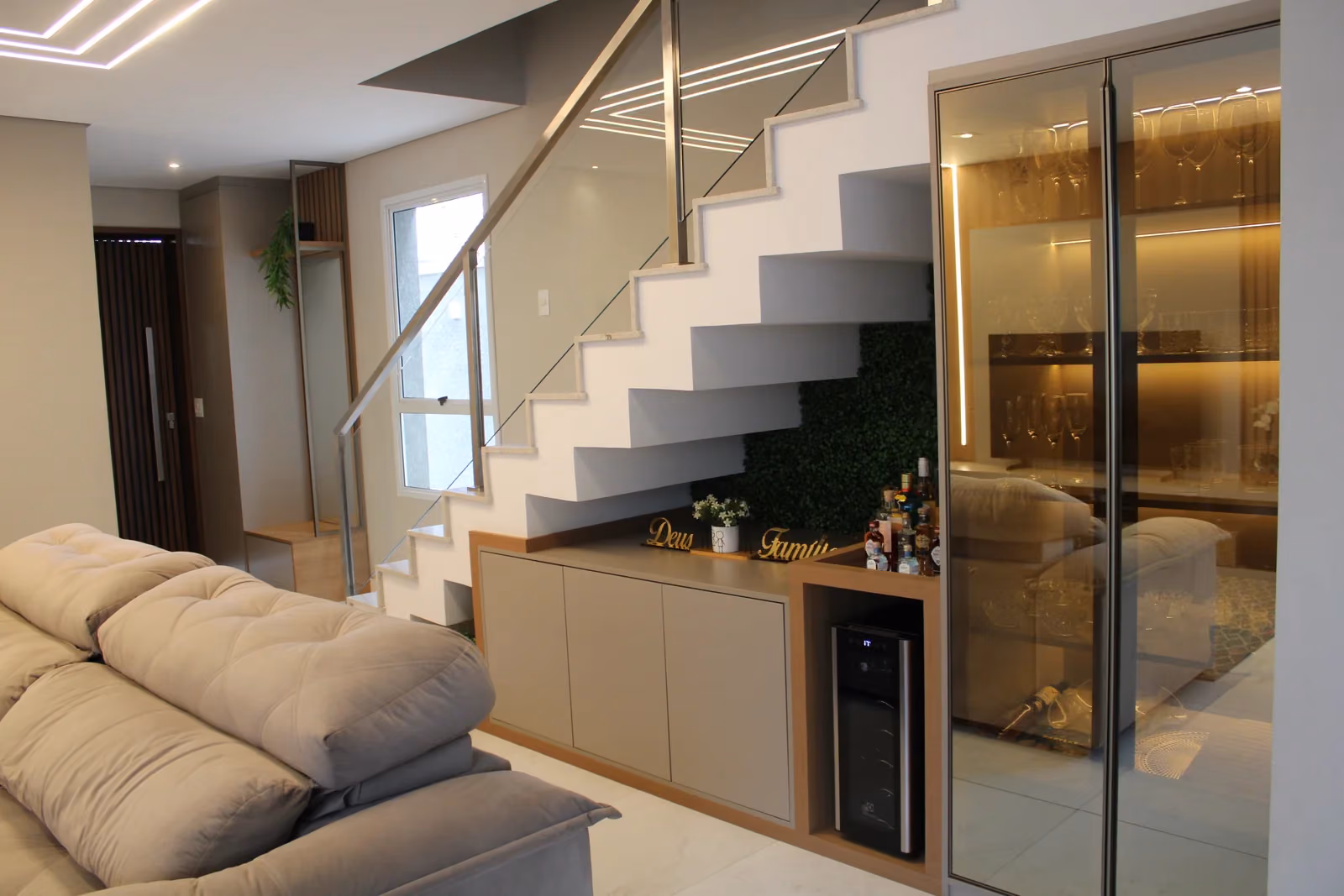 Bar e cristaleira sob medida em residência em Curitiba — projeto de design de interiores com iluminação de destaque e marcenaria premium.