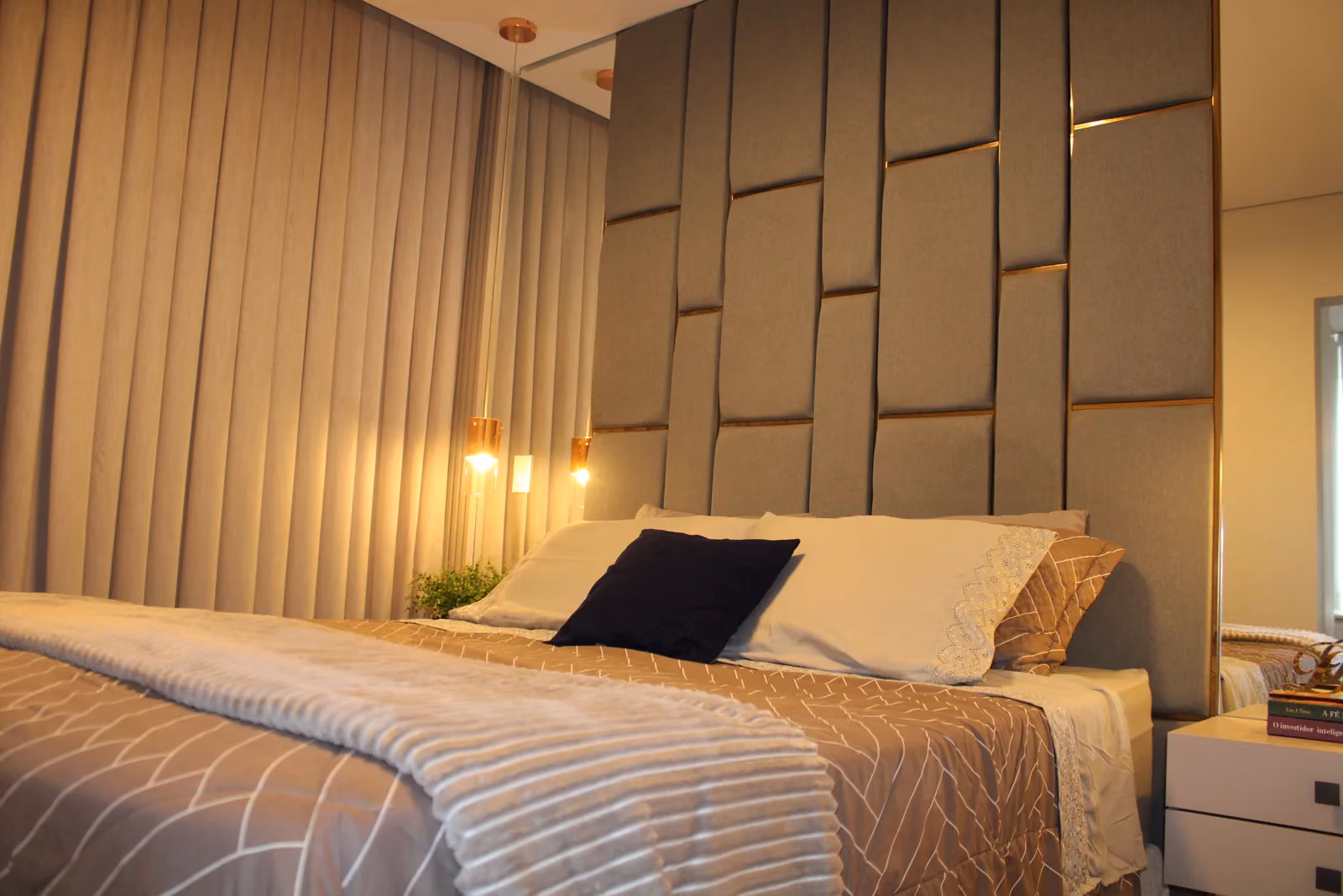 Suíte casal elegante com projeto de interiores personalizado em Curitiba — conforto, texturas e iluminação acolhedora.